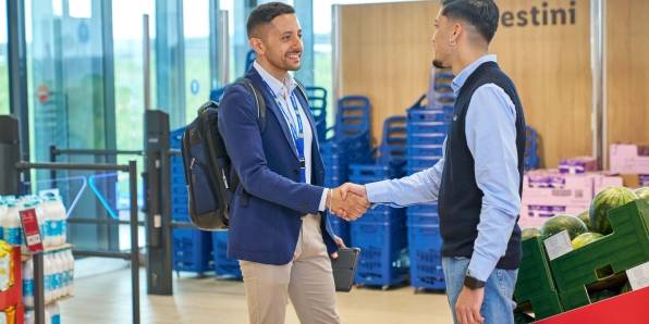 area manager e apprendista assistant store manager si stringono la mano