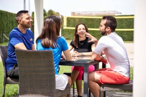 colleghi sorridenti seduti al tavolo esterno