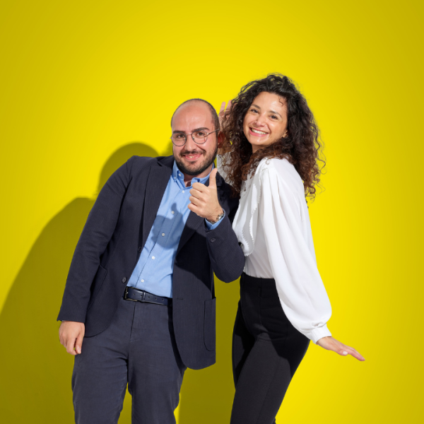 donna e uomo in abbigliamento d'ufficio sorridono e scherzano in camera